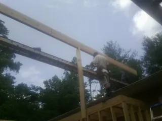 Carpenter setting a ridge beam over a new addition frame — Ice Dam Removal by Roofing Brothers in Langley